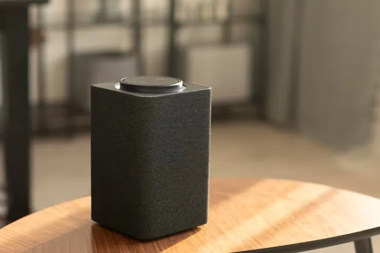 Altavoz inalámbrico compacto sobre una mesa de madera, imagen ilustrativa